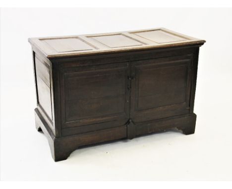 An 18th century oak mule chest, later converted to a cupboard, the rectangular top with three invert moulded panels above a p