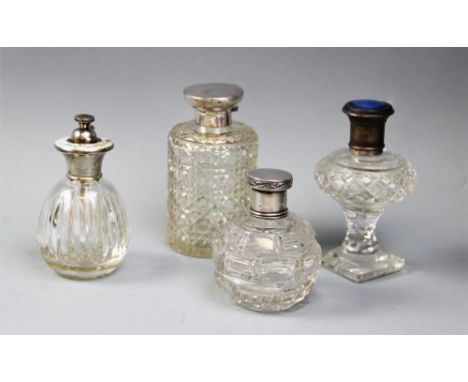 Three cut glass dressing table jars and an atomiser, including an Edwardian silver topped example, William Hutton & Sons, Lon