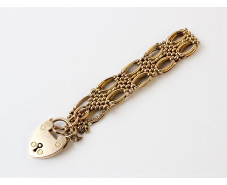 A 9ct gold gate link bracelet, 18cm long, suspending a 9ct gold heart-shaped padlock fastener, Birmingham 1907, weight 15.6gm
