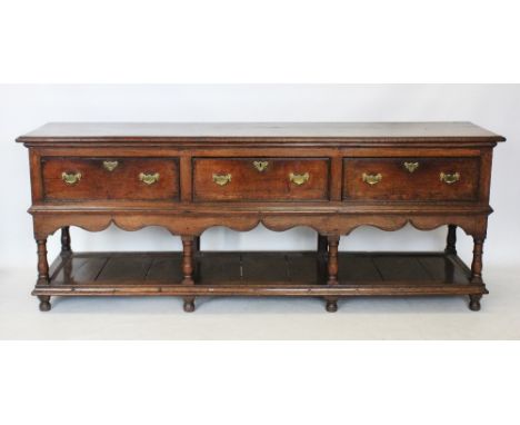 An early to mid 18th century Montgomeryshire oak dresser, the rectangular moulded two plank top above three frieze drawers ap