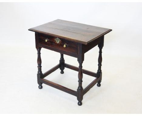 An early 18th century oak side table, the rectangular moulded top above a single frieze drawer applied with brass knob handle