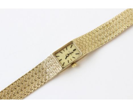 A lady's vintage 9ct gold Omega wristwatch, comprising a rectangular gold toned dial with baton markers, set to a plain polis
