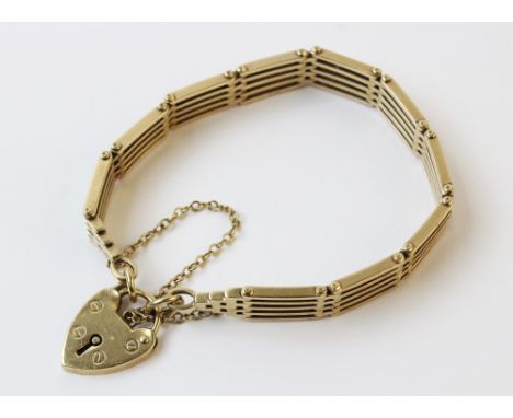A 9ct gold bracelet, the yellow gold gate-link chain stamped '9' and '.375', 17cm long, suspending a 9ct gold heart-shaped pa