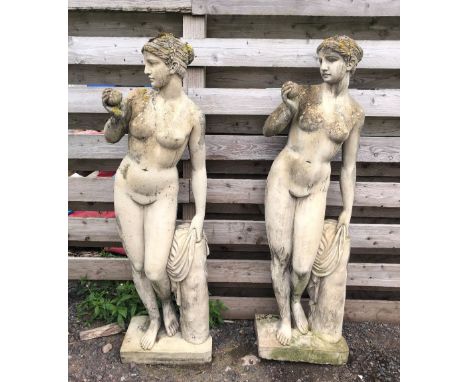 Two large female garden statues, each modelled standing contrapposto beside a trunk, 145cm H (2) 