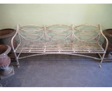 An early 20th century wrought iron painted garden bench, with lattice work design and shaped front. Condition Report: Both ou