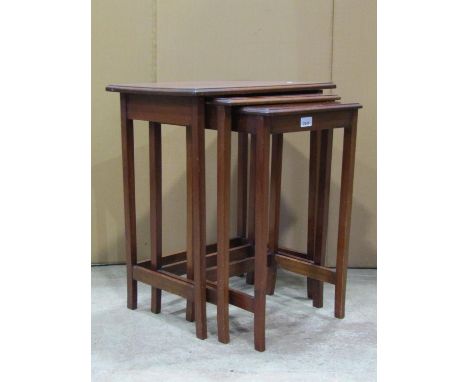 A nest of three Edwardian mahogany occasional tables of rectangular form raised on slender square tapered supports, partially