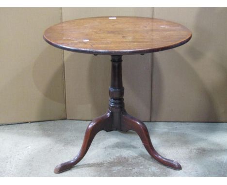 A Georgian mahogany snap top occasional table of circular form, the one piece top 73 cm in diameter raised on a turned vase s