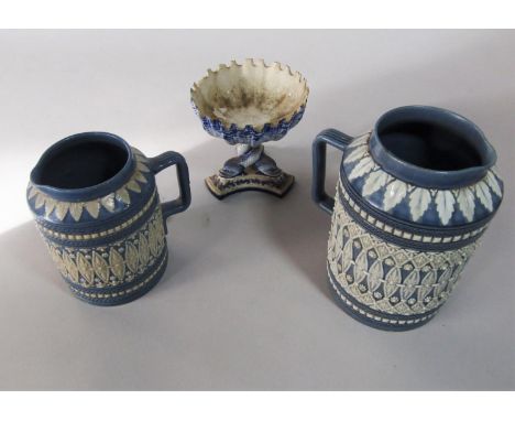 Two Doulton Lambeth graduated blue ground jugs with moulded lozenge and flower head detail in white and with various impresse