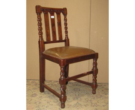 A set of six 1920s walnut slat back dining chairs with drop in upholstered seats raised on barley twist and block supports un