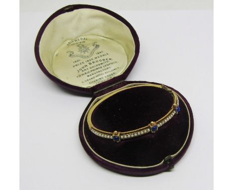 18ct aesthetic movement hinged bangle set with lapis lazuli and seed pearls, 13.8g, contained in a John Brogden case 