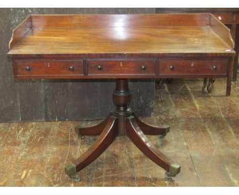 An unusual mid Victorian mahogany writing table of rectangular form with three quarter gallery raised on a central vase shape