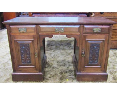 An Edwardian walnut kneehole desk/dressing table with associated top over three frieze drawers and cupboards enclosed by rect