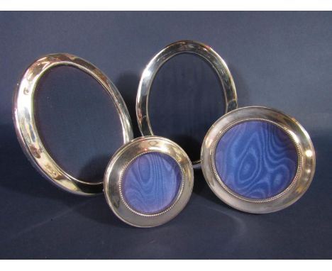 Pair of silver applied oval easel photo frames, 17 x 13cm, together with a further graduated pair of tondo frames with beaded