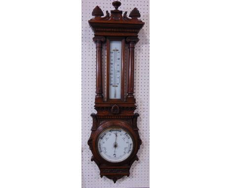 Architectural oak barometer/thermometer, with carved pediment and barometer flanked by turned Corinthian columns, by Comitti 