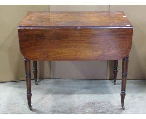 A Regency mahogany Pembroke table fitted with the usual arrangement of one real and one dummy frieze drawer raised on ring tu