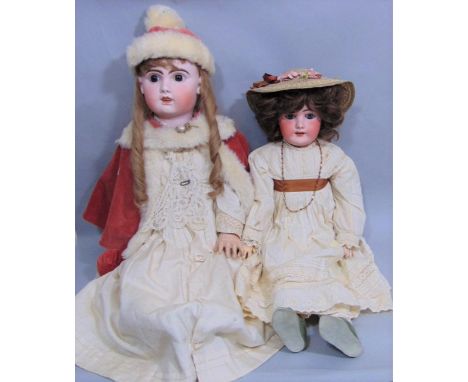 2 large well dressed bisque head dolls with jointed composition bodies, pierced ears, open mouth with teeth. Larger doll is 7