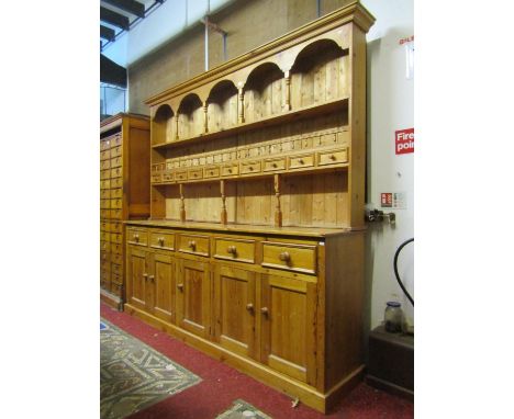 A large Victorian style pine kitchen dresser, the base enclosed by five rectangular panelled doors beneath five frieze drawer