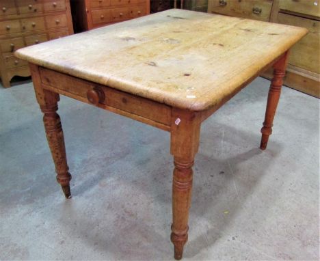 A Victorian stripped pine kitchen table of rectangular form with moulded outline, rounded corners and fitted with an end frie