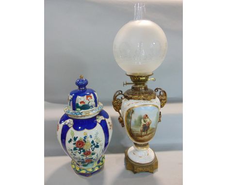 A good quality hand painted porcelain oil lamp, decorated with a panel of gentleman holding a child in a rural location, with