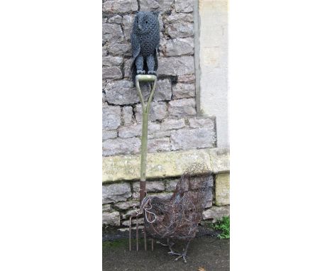 A novel garden ornament/feature of a wire work owl mounted on a vintage garden fork handle together with a further wire work 