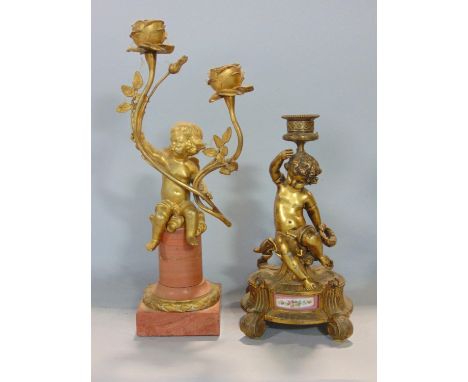Ormolu novelty twin branch candlestick in the form of a seated cherub upon a Corinthian plinth, 32 cm high, together with a f