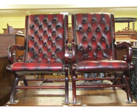 A pair of Georgian style library chairs with scrolled arms, upholstered in button back oxblood red leather upholstery 