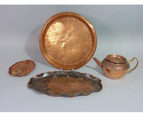 An Arts &amp; Crafts Cornish copper tray of oval form with raised crimped edge, fish and hammered detail, together with a fur