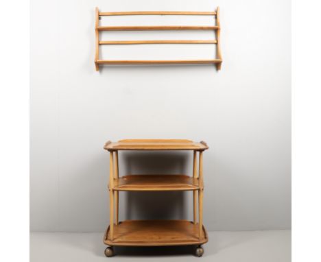 ERCOL TEA TROLLEY &amp; PLATE RACK. A three tier light elm and beech tea trolley, raised on roller castors (74.5cms high, 70.