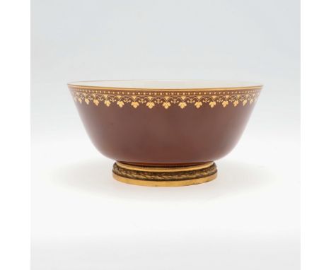 A SEVRES PORCELAIN BOWL ON GILT METAL BASE - PARIS RETAILER 'RISLER &amp; CARRE'. A porcelain bowl with a brown glaze to the 