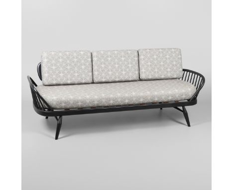 A MODERN ERCOL DAY BED. A modern ebonised day bed, after Model 355 designed by Lucian Ercolani. With a wide panel back and op