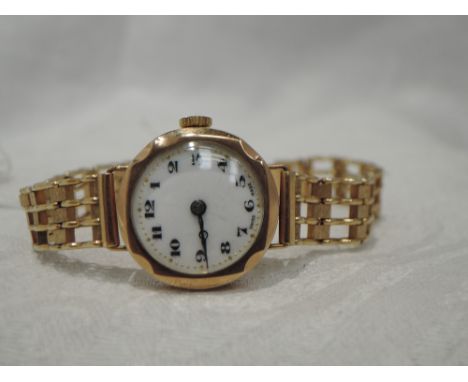 A lady's 9ct gold vintage wrist watch having an Arabic numeral dial with gilt minute dots to a white enamel face on a later 9