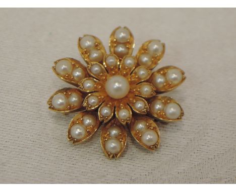 A yellow metal floral brooch having seed pearl decoration, no marks, tested as 15ct gold
