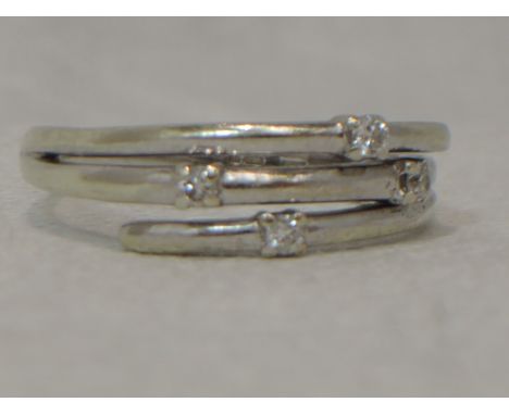 A lady's dress ring having four diamond chips on a triple open band on a 9ct white gold loop, size N.&nbsp; APPROX 2.4G