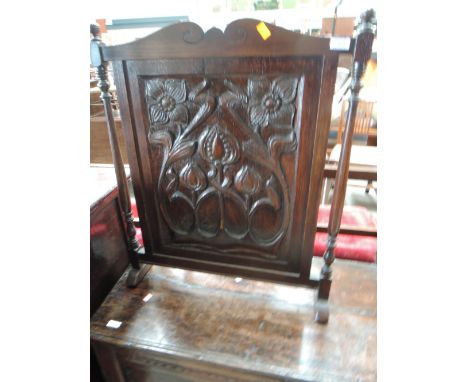 A late Victorian oak firescreen having carved Art Nouveau panel