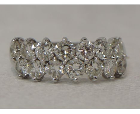 A lady's dress ring having an off set double row of brilliant cut diamonds, total approx  1.5ct in a claw set mount on an 18c