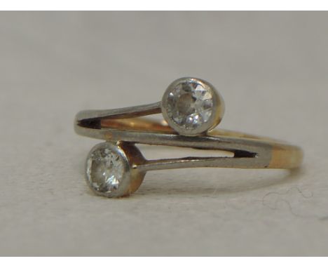 A lady's dress ring having two diamonds, total approx 0.25ct in collared settings in cross over mount on a yellow metal loop 