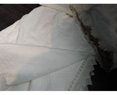 A pair of early 20th century large white bed coverlets with intricate edging, having almost embossed detailing, good conditio