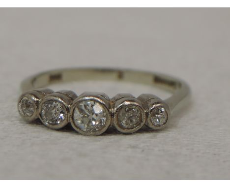 A lady's dress ring having five graduated diamonds, total approx 0.035ct in a collared mount on a white metal loop stamped 18