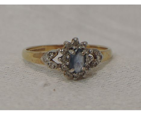 A lady's dress ring having a powder blue sapphire and diamond cluster to diamond chip set open shoulders on a 9ct gold loop, 