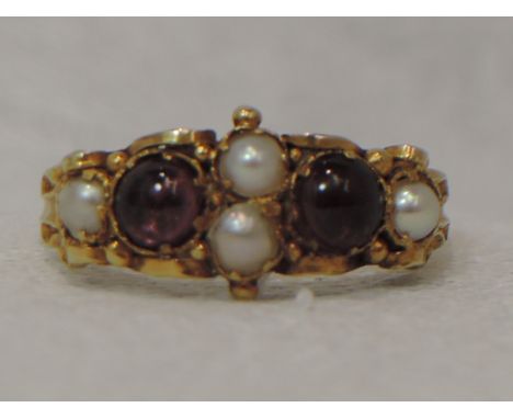 A lady's dress ring having amethyst cabouchon and seed pearl decoration in a decorative mount on a yellow metal loop, no mark