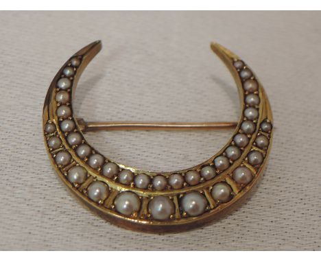 A yellow metal crescent brooch having seed pearl decoration, no marks, tested as 9ct gold