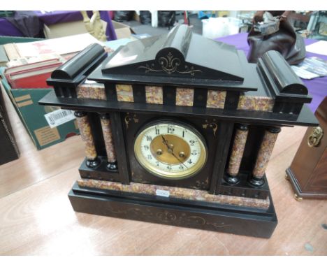 A Victorian black and rouge marble mantel clock of architectural design having circular Roman numeral dial and striking movem