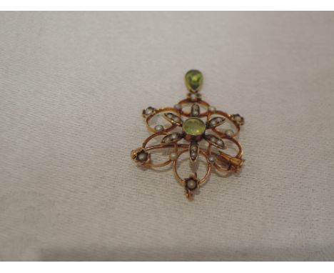 An Edwardian yellow metal pendant/brooch stamped 9ct having peridot and seed pearl decoration