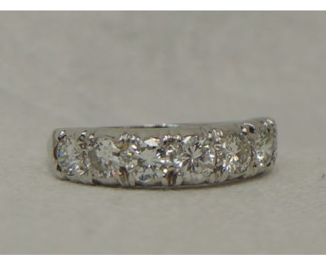 A lady's half eternity ring having seven brilliant cut diamonds, total approx 1.1ct in a claw set mount on a white metal loop