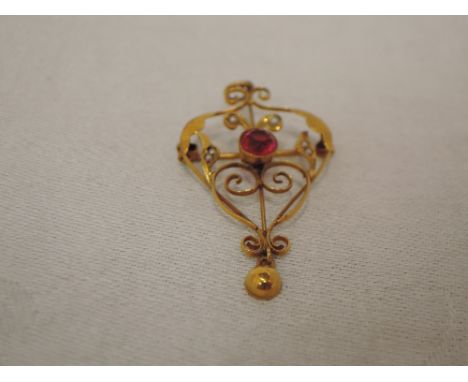 An Edwardian yellow metal pendant/brooch stamped 9ct having pink paste and seed pearl decoration