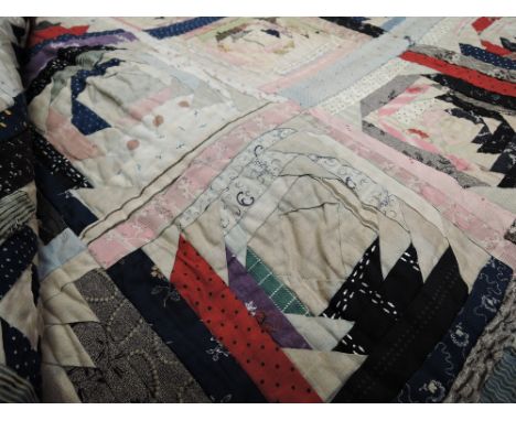 An intricate early 20th century patchwork bed cover, approx a double in size, some age related wear and marks.