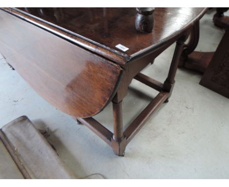 An early 20th century oak and drop leaf dining table in the 18th century style, on turned gate legs