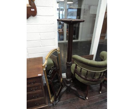 A 19th century mahogany torchere/jardiniere stand having rim top on pillar and carved baluster and column with triple splay l