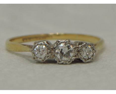 A lady's dress ring having a trilogy of diamonds, total approx 0.25ct in an illusionary setting to knife blade shoulders on a