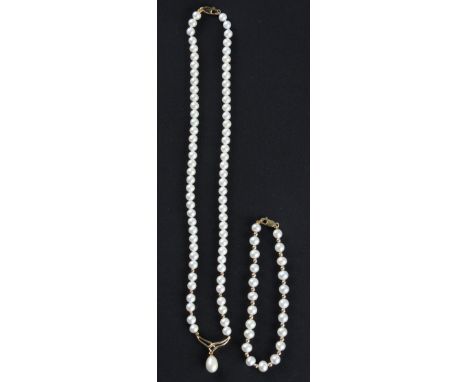 A part suite of pearl jewellery, comprising a string of pearls with dropper suspended from open metalwork and yellow metal sp